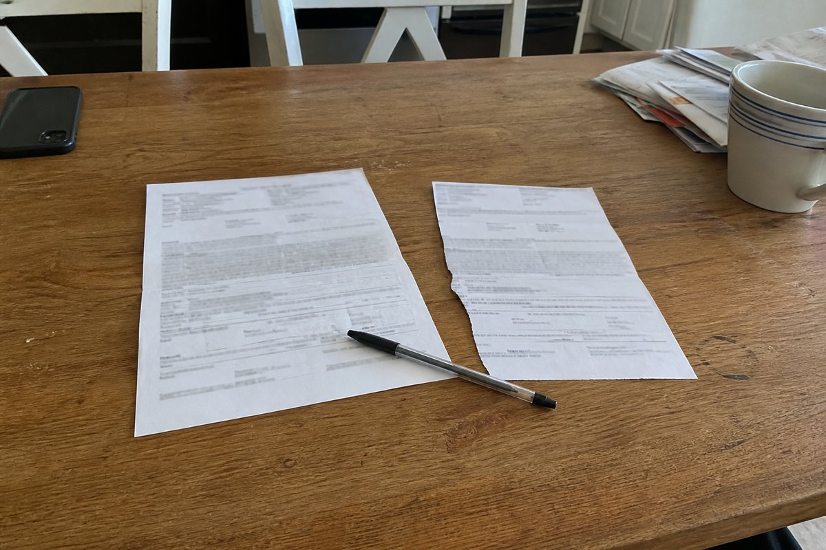 A contract, pen, and duplicate cancellation form resting on a customer's kitchen table.